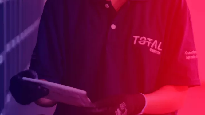 Uma pessoa vestindo camisa escura com “TOTAL EXPRESS” bordado no peito e luvas segura um pacote. O fundo é iluminado com luzes vermelhas e azuis, criando um efeito gradiente.