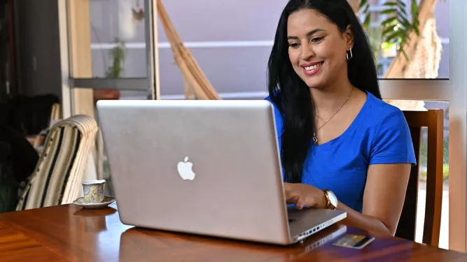 Mulher trabalhando em um notebook, representando o empreendedorismo digital e a flexibilidade do trabalho online.