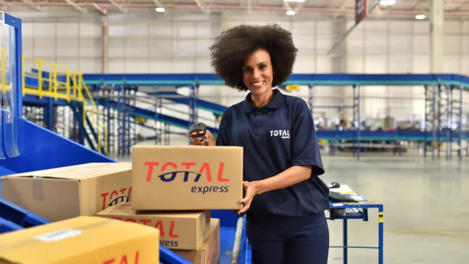 Mulher em centro logistico separa encomendas para carga dedicada 