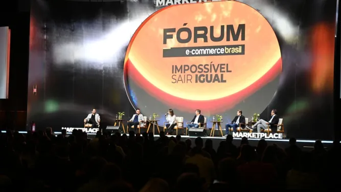 Palestrantes debatem no palco do Fórum E-Commerce Brasil diante de uma plateia.