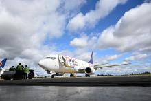 Avião de transporte aéreo de carga no aeroporto, com operários realizando atividades de carga e descarga.