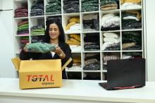 Empreendedora confere as roupas encomendadas e faz a gestão de compras do negócio