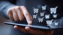 Pessoa utiliza um tablet com ícones flutuantes de carrinhos de compras, representando a análise digital do comportamento de compra.