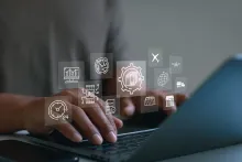 Mãos digitando no notebook com ícones digitais de rastreamento de entrega internacional.