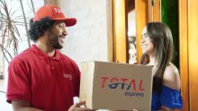 Atendente da Total Express recebe caixa de cliente em processo de coleta reversa.