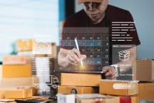 Pessoa selecionando data no calendário virtual sobre caixas para a entrega agendada.