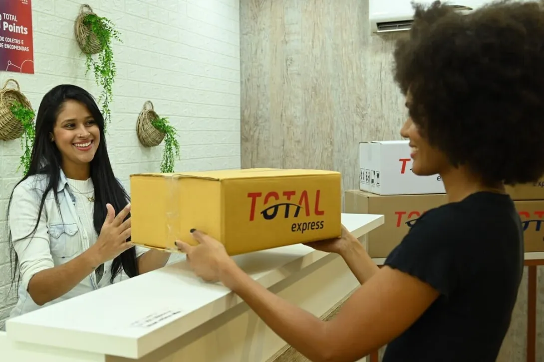 PUDO: Uma atendente entregando a encomenda para uma cliente.