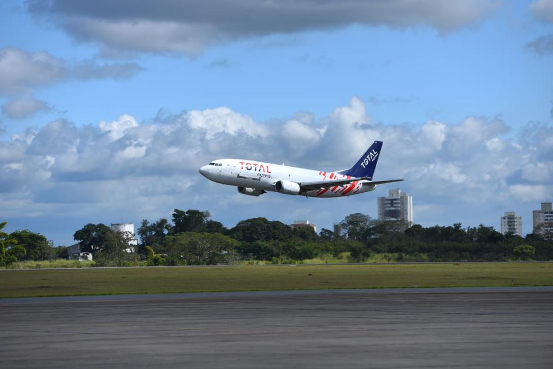Cross border: Avião com logo da Total Express decolando.