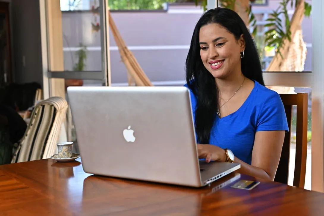 Mulher trabalhando em um notebook, representando o empreendedorismo digital e a flexibilidade do trabalho online.
