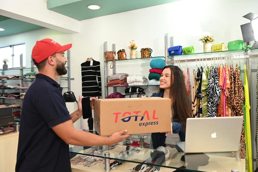 Imagem mostrando o processo de "shipping from store", com um cliente recebendo um pacote de uma loja, enquanto o atendente finaliza a entrega.