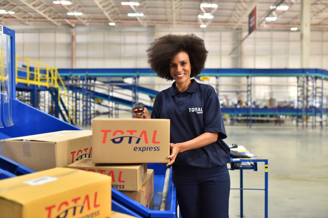 Mulher em centro logistico separa encomendas para carga dedicada 